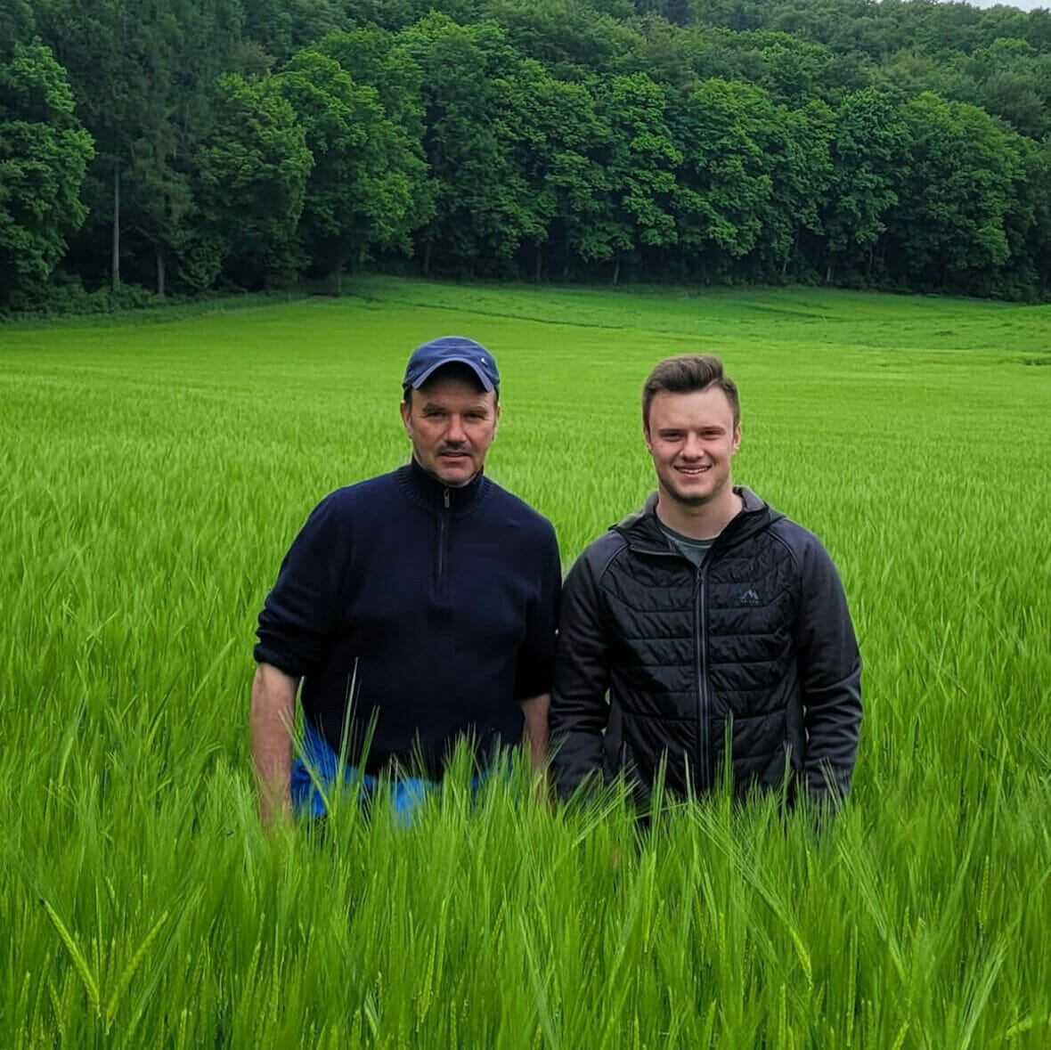 Zwei Männer stehen auf einer grünen Wiese.